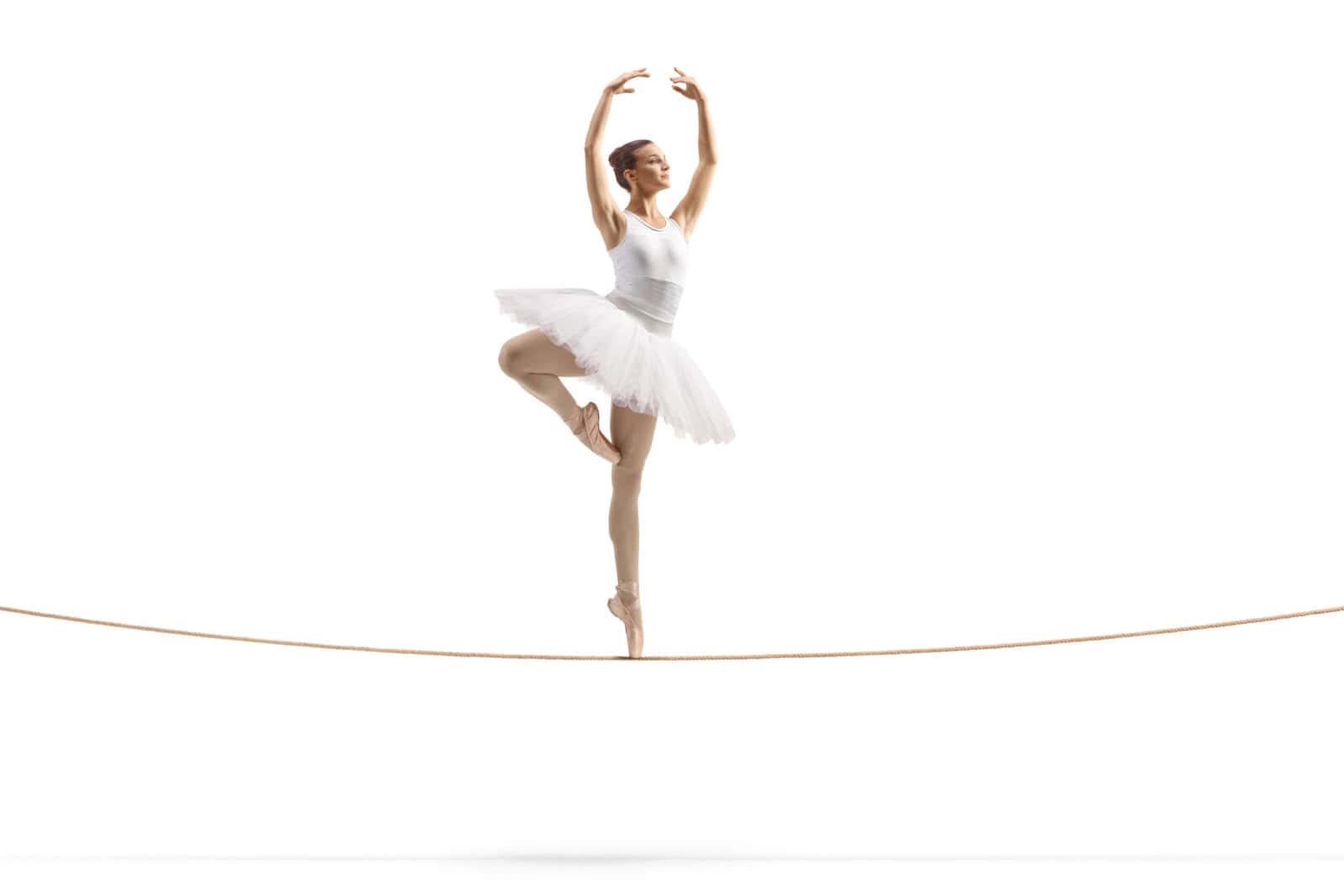 Full length shot of a ballerina dancing on a tightrope Full length shot of a ballerina dancing on a tightrope isolated on white background