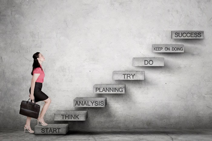 Caucasian business woman looking up ready to climb the success staircase Caucasian business woman looking up ready to climb the success staircase